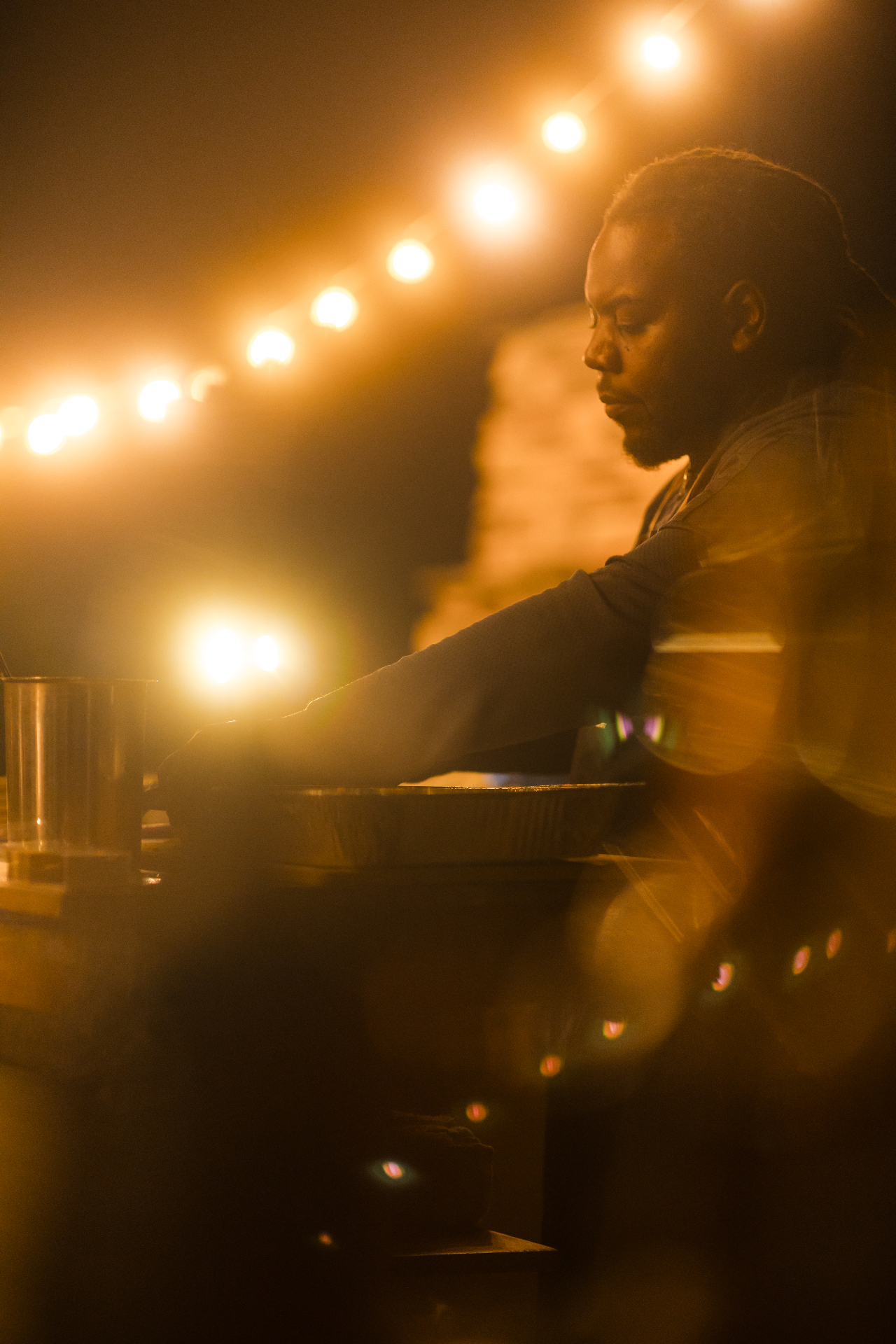 Chef working under warm string lights at an evening catering